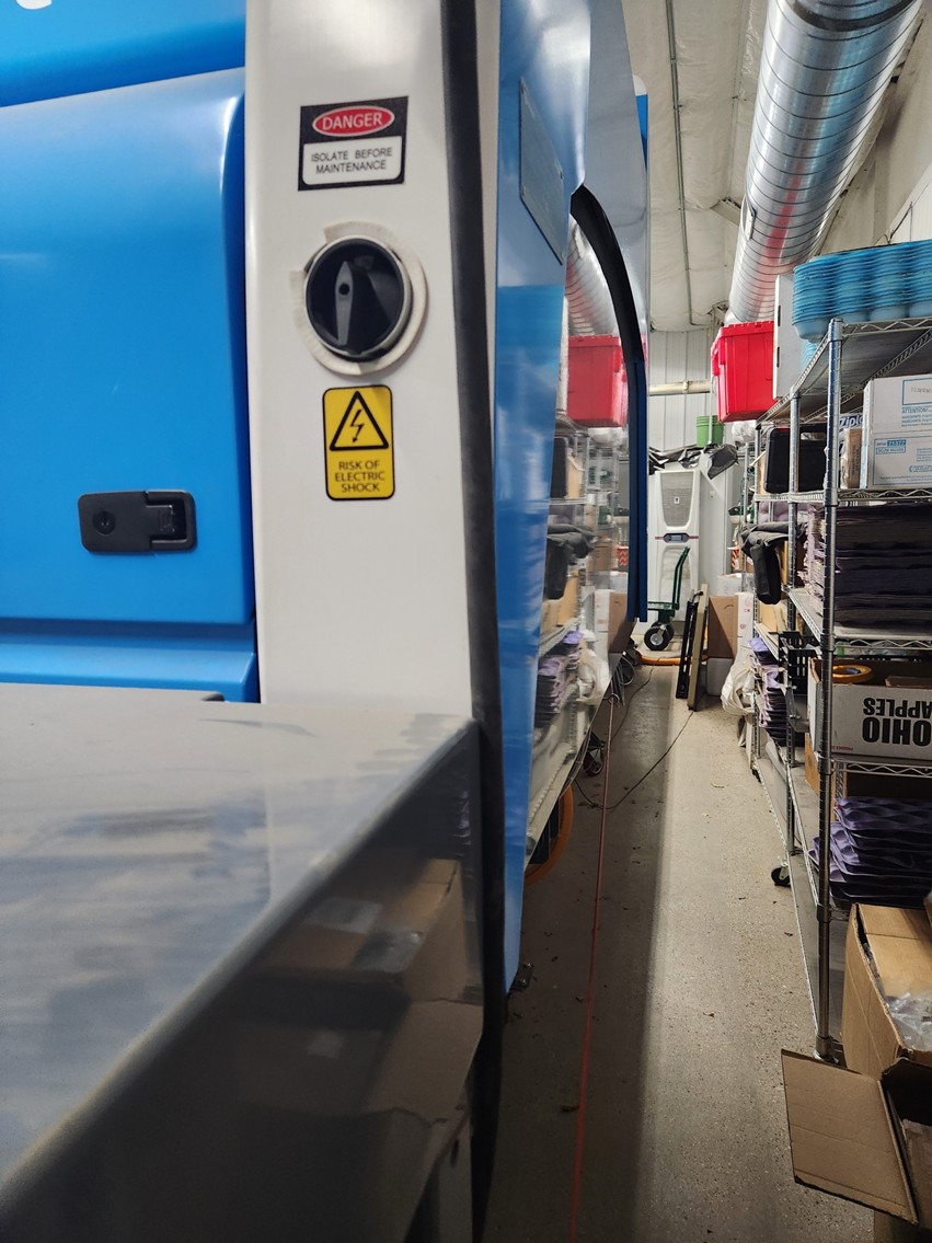 A black switch in an up-and-down position on the back side of a Compac line machine.